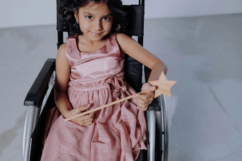 A little girl in a wheelchair.
