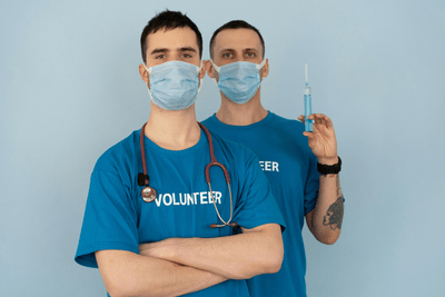 Two volunteer medical experts standing in blue shirts.