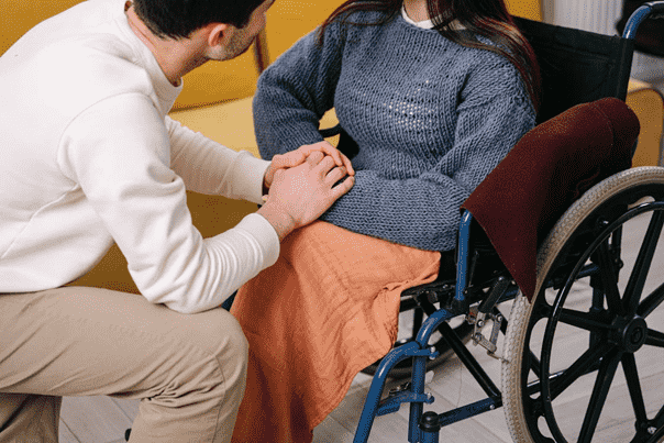 a person holding hands with a woman in a wheelchair