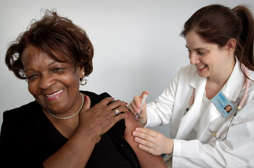 A medical professional giving a woman a shot