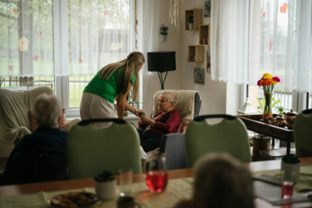  A woman giving a cup to a senior