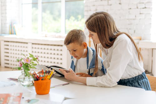 A picture of a woman helping a kid with a learning disability