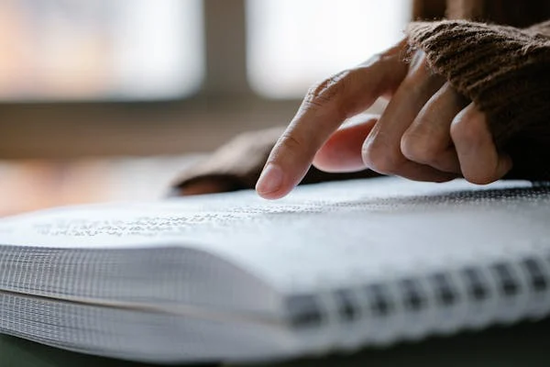 Person reading Braille with their finger.