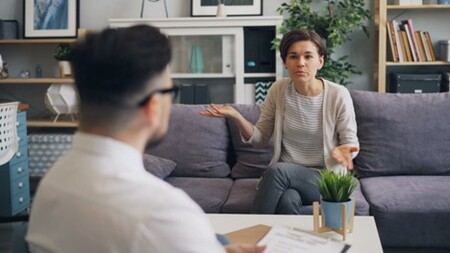 A male support worker talking to a female resident with mental health issues