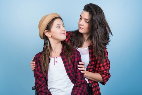 A female support worker with a teenage girl, both wearing a similar shirt