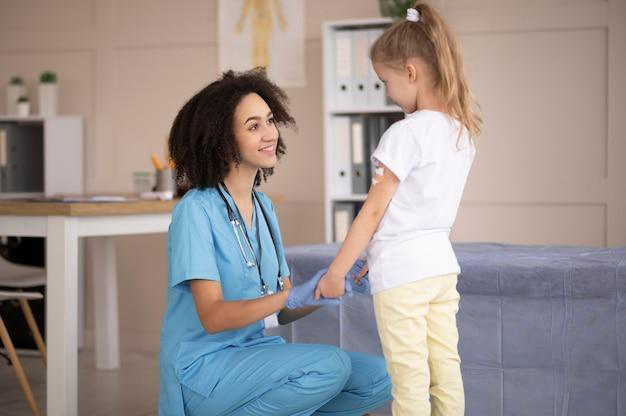 Doctor gently supporting a child.