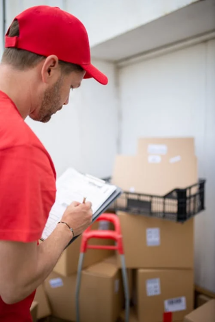 man writing something on paper while standing