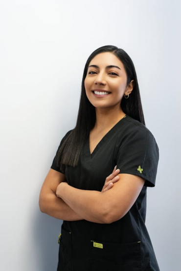 woman smiling while wearing black scrubs 