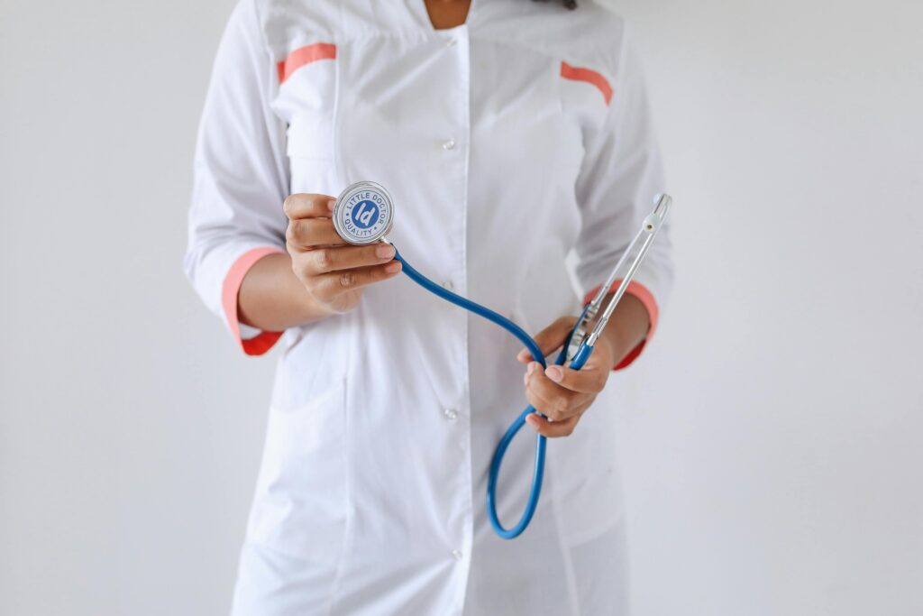 A physician holding a stethoscope in a clinical setting