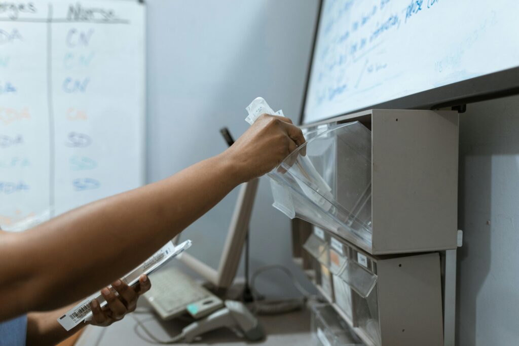 Support worker retrieving medication from a shelf in a compliant nursing home