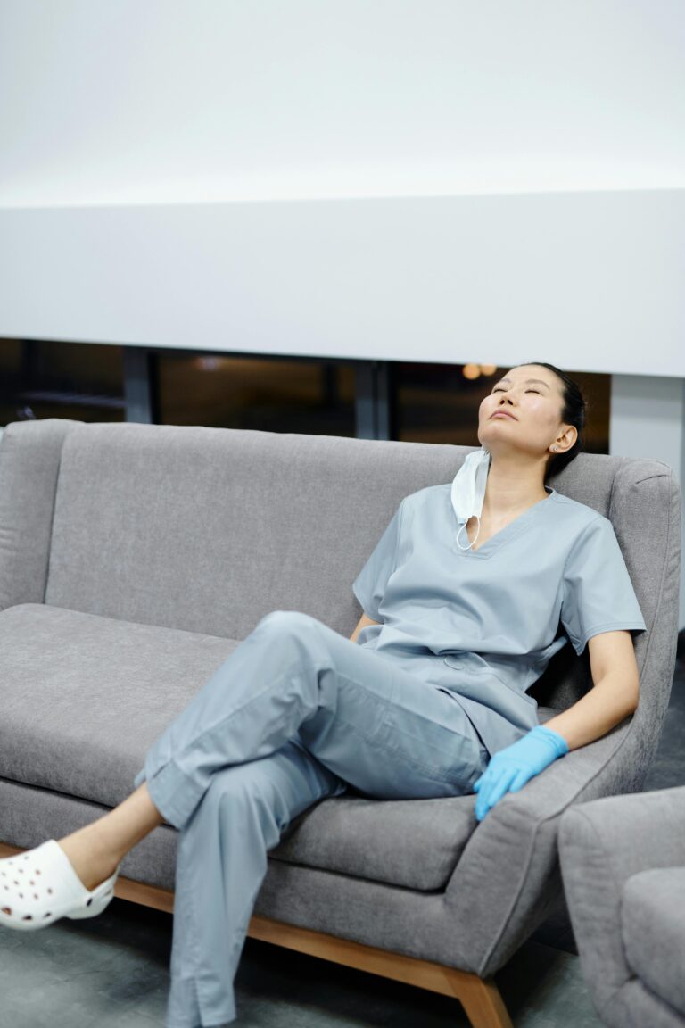 Support worker resting her head on a couch due to exhaustion in a care facility