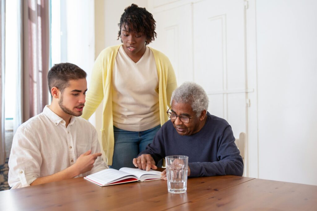 Support workers supporting an elderly man with mobility in a nursing home