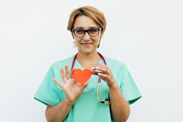 A support worker is holding a heart-shaped cutout in her hands.