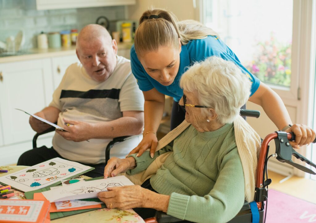 support worker assisting elderly residents during a seated activity session