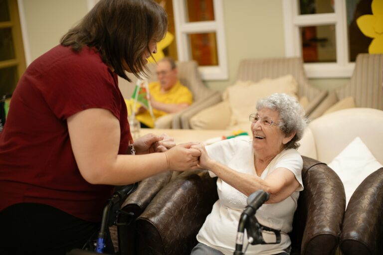 support worker holding hands with an elderly resident during a friendly interaction
