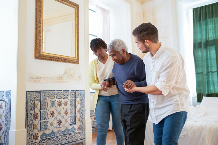 Support workers helping an elderly resident walk safely at home