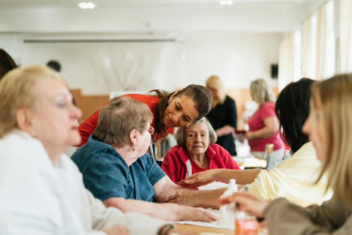 Senior residents participating in a social activity with support workers in a retirement village