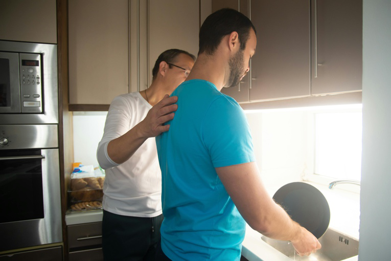 Support worker helping a teenager with daily routines in supported accommodation