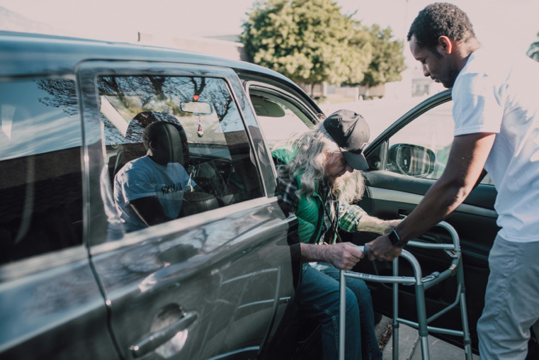 Support worker helping an elderly resident with mobility assistance