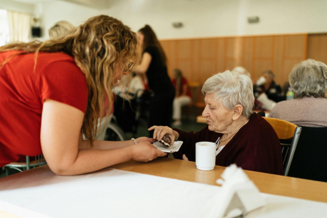 Support worker spending time with an elderly resident during a daily activity
