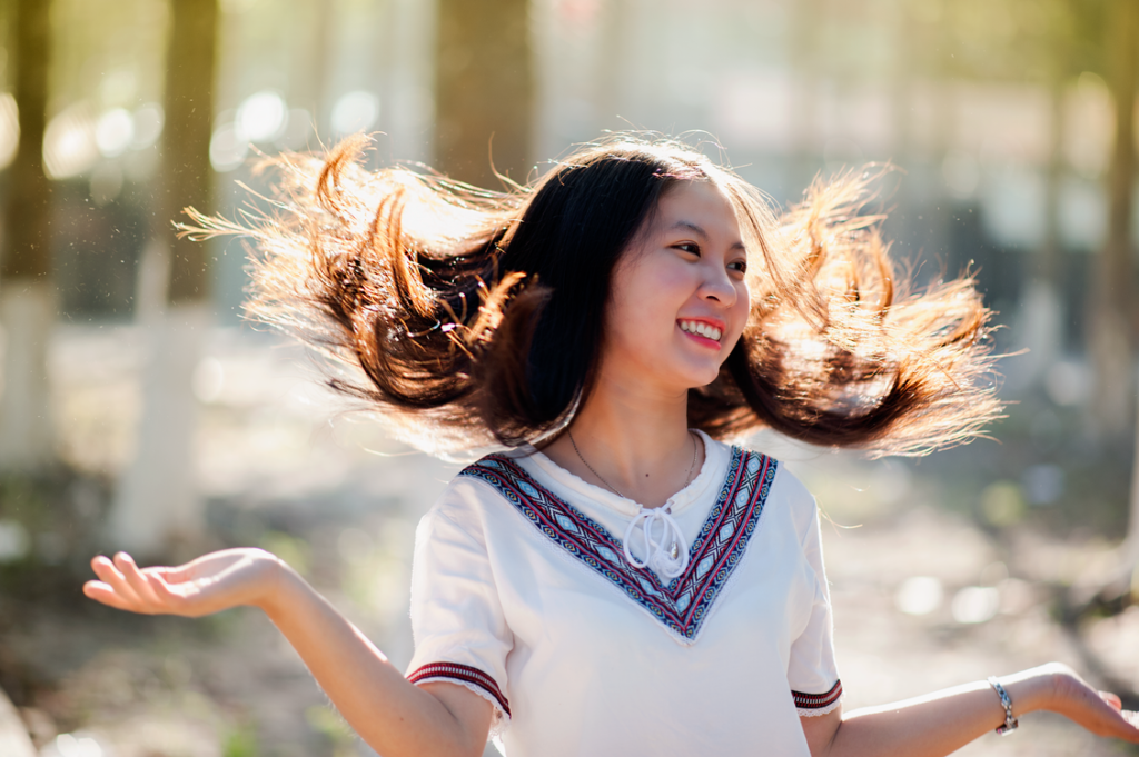 A young person laughing and enjoying a carefree moment outdoors.