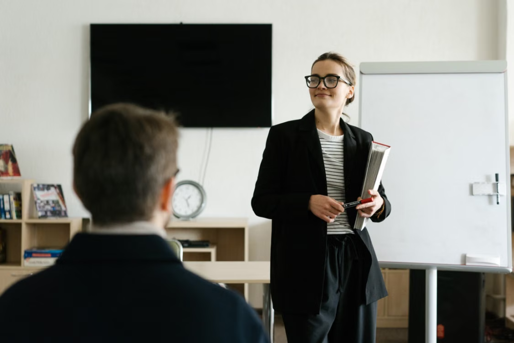 A manager presenting to colleagues in front of a whiteboard during a planning session.