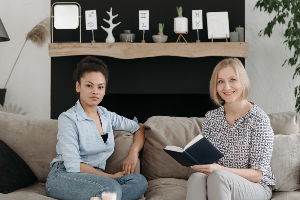 A qualified support worker spending time with a young person in a relaxed home setting.