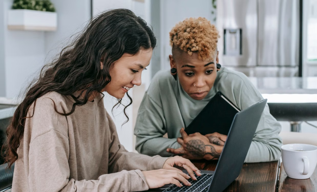 Two people looking at a laptop together during a focused conversation.